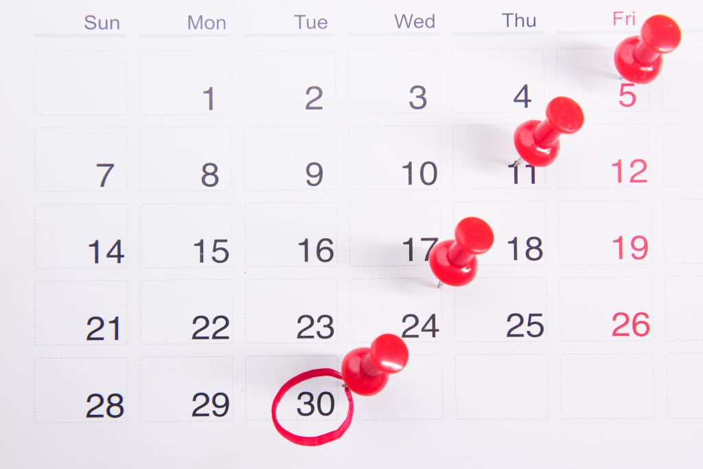 pexels-photo-9810172-9810172 Close-up of a calendar with red push pins marking important dates, emphasizing deadlines.